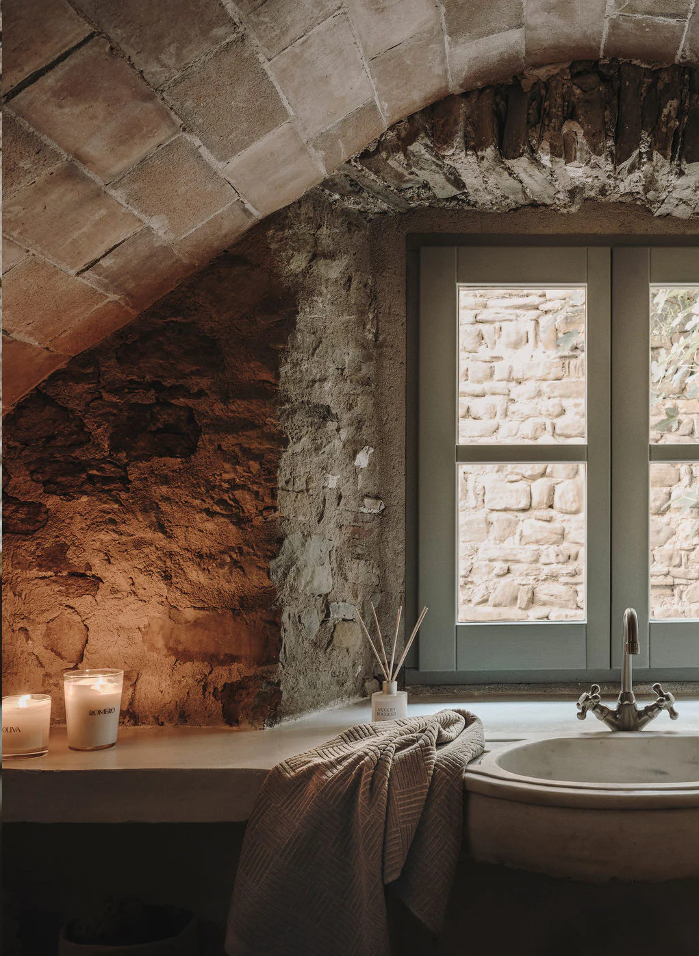 salle de bain voûtée avec mur en pierres