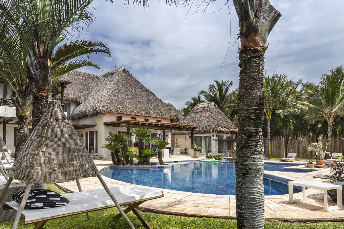 maison avec piscine et toit de palmes