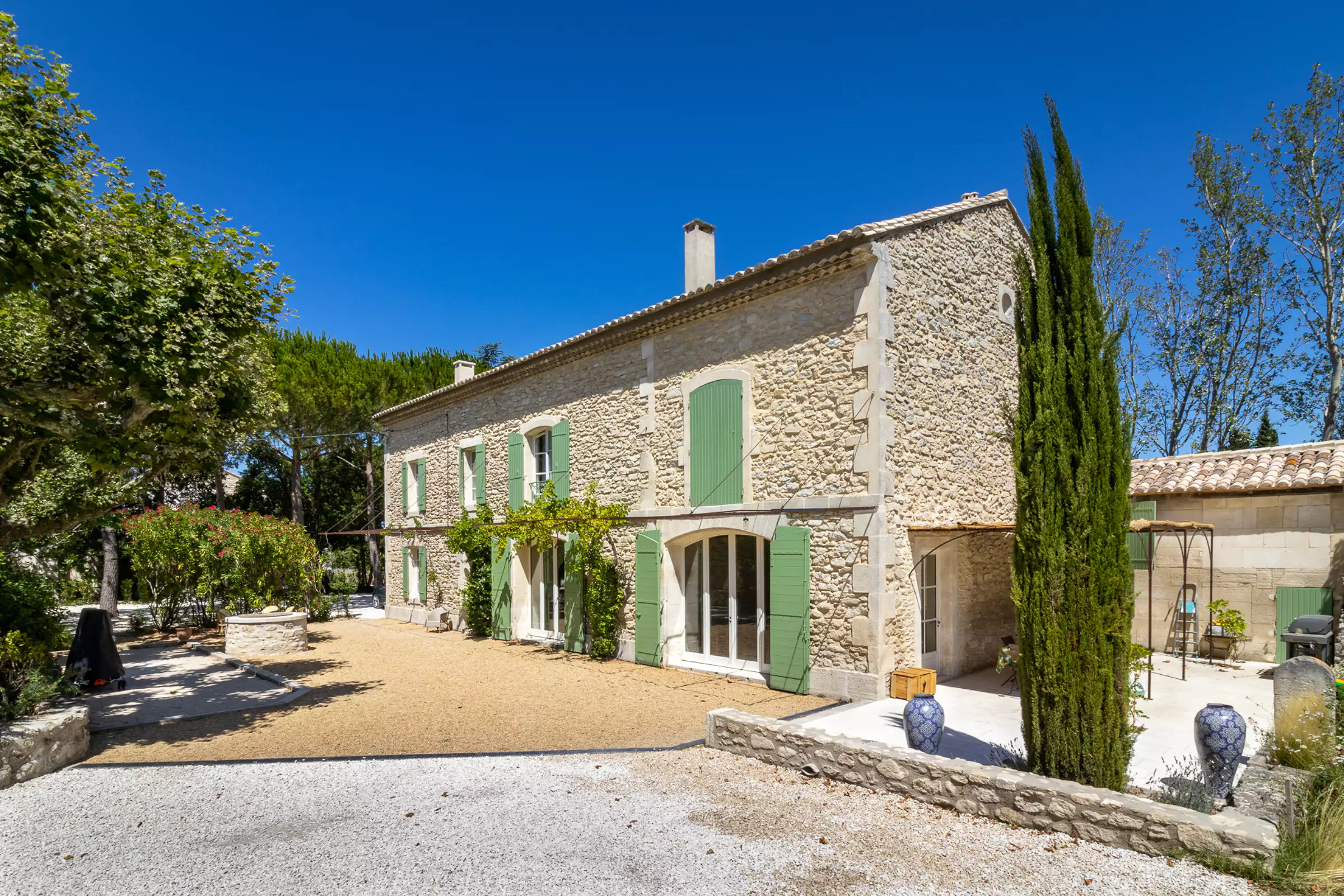 Une maison en pierres aux volets verts en Provence