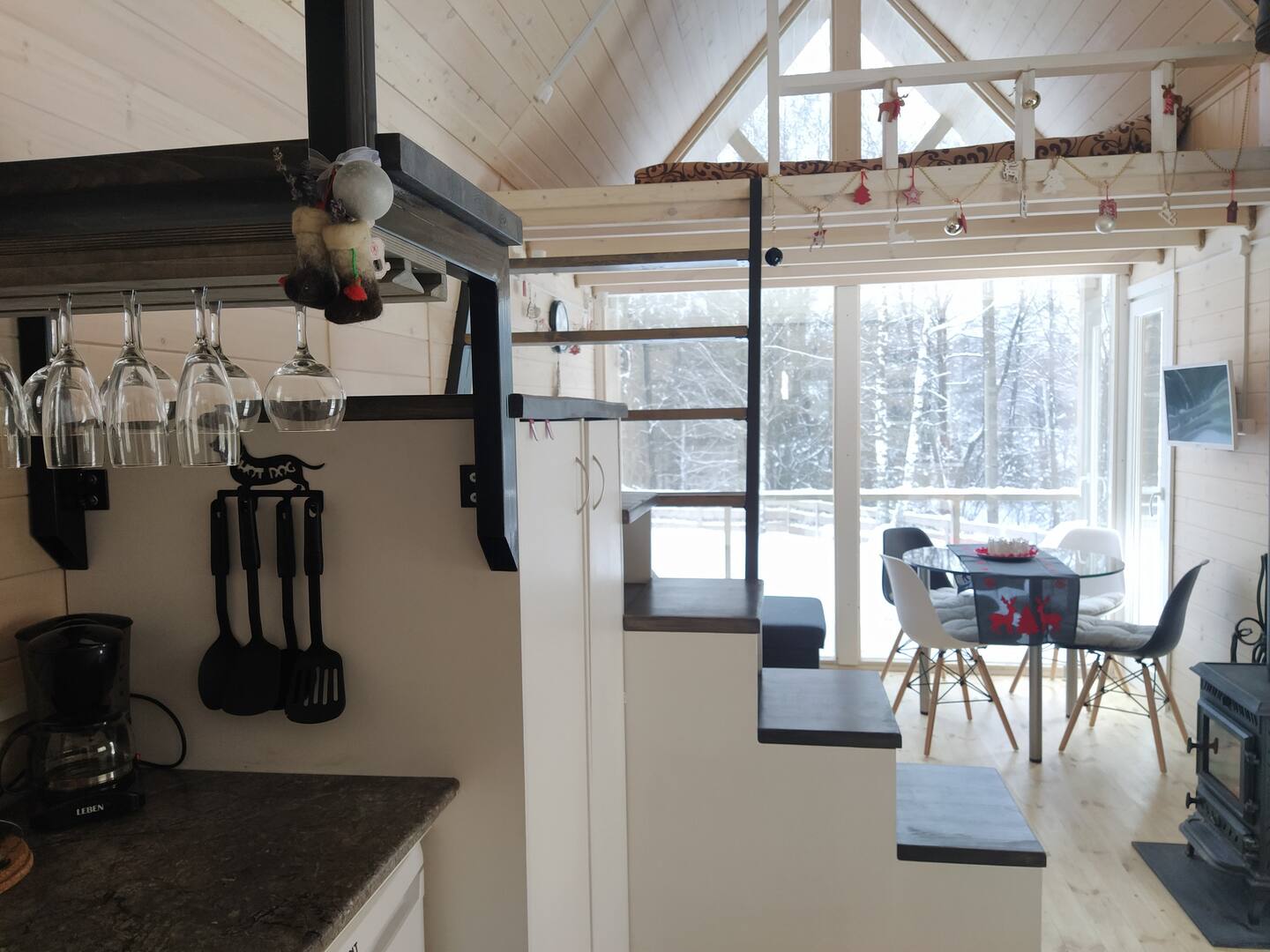 Une petite maison en bois clair dans la neige au milieu des arbres