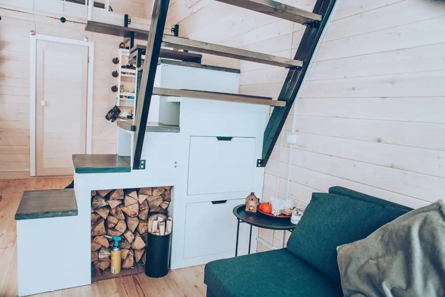 Une petite maison en bois clair dans la neige au milieu des arbres