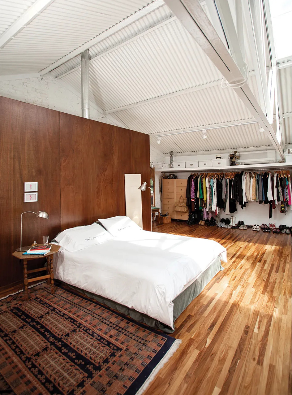 a bedroom with an open wardrobe in the attic of the house