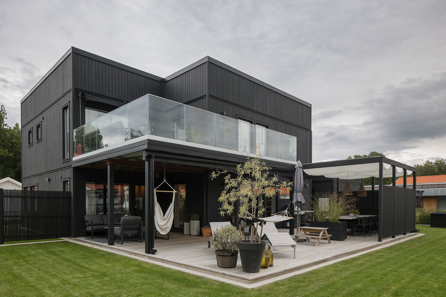 maison bois noir avec terrasses couvertes