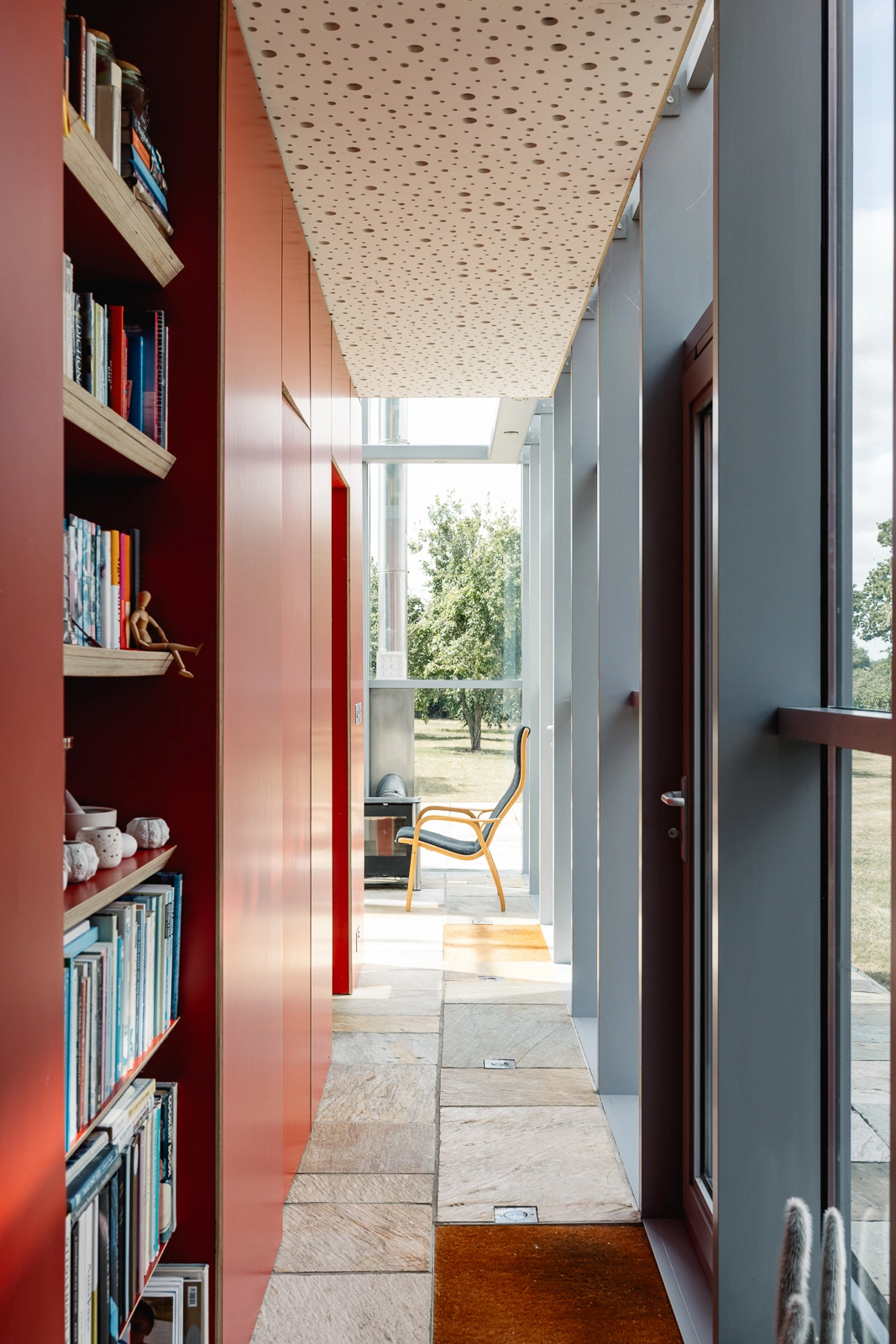 couloir peint en rouge avec bibliothèque